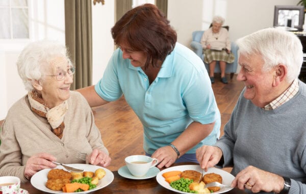 caregiver checking on memory care patients dinners