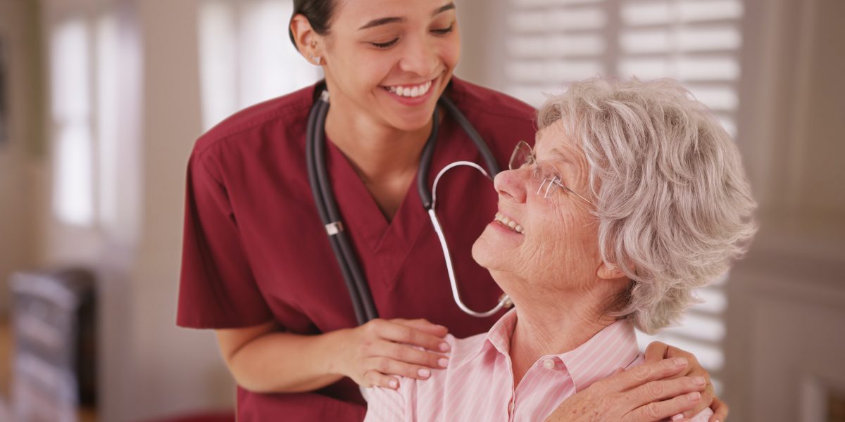 female caregiver smiling at senior with dementia